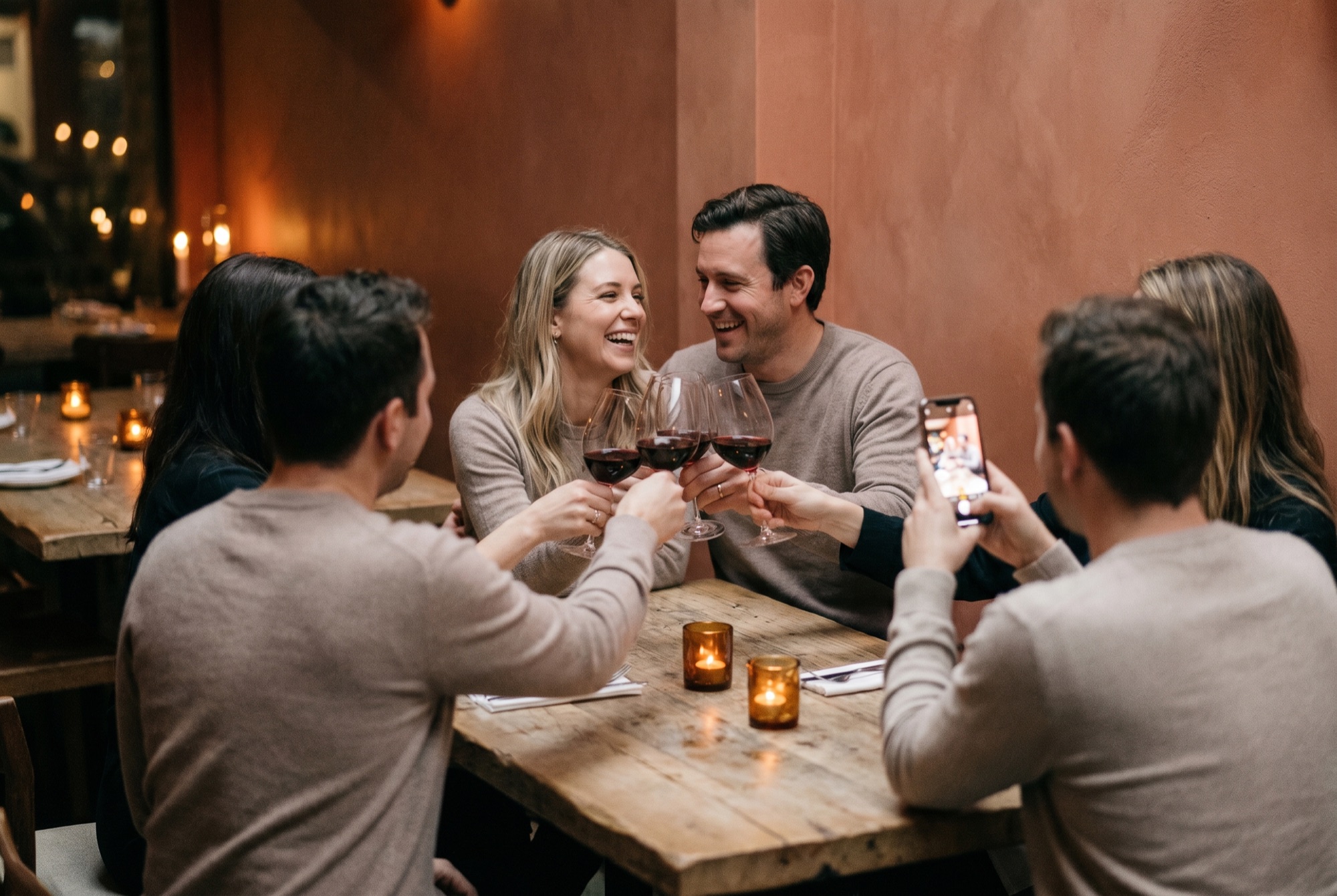 Friends toast a couple at an intimate anniversary dinner.